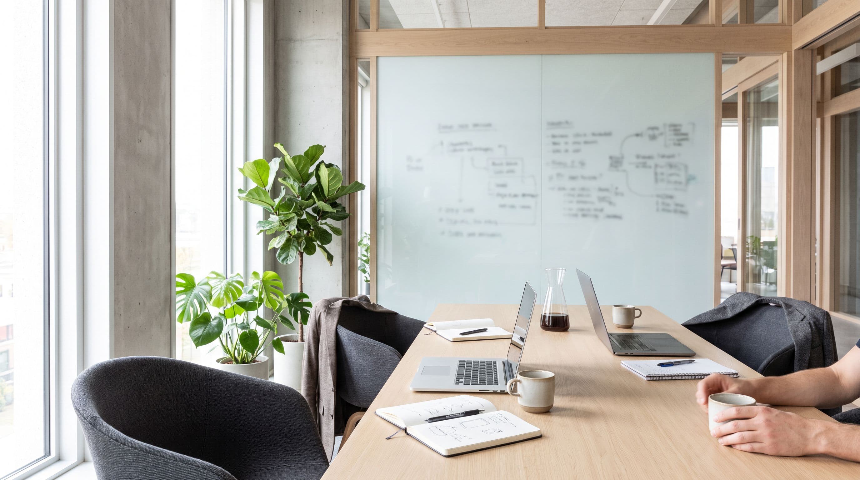 A bright two-person workspace with laptops and a whiteboard